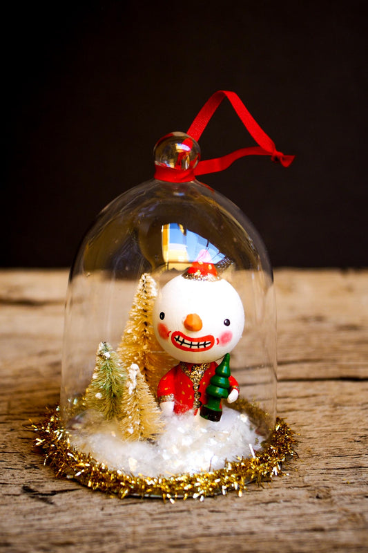 An original handmade christmas tree ornament by Idania Salcido. A clear domed diorama with a holiday scene with Santa Claus elves, Christmas Trees, Elves, Gifts and magical glitter deer. Perfect to decorate your Christmas Tree, your mantelpiece or to be used as accents on a dinner table.