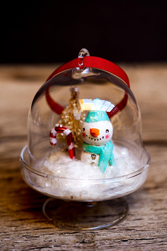 An original handmade christmas tree ornament by Idania Salcido. A clear domed diorama with a holiday scene with Santa Claus elves, Christmas Trees, Elves, Gifts and magical glitter deer. Perfect to decorate your Christmas Tree, your mantelpiece or to be used as accents on a dinner table.