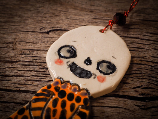 An original handmade Halloween ornament by Idania Salcido, Danita Art. Each ornament is hand carved with pumpkins, witches, cats, jack-o-lanterns and moons.  Made with fired glazed ceramics, this little witch, jack-o-lantern and cat is carved with delicate patterns that make each ornament a one of a kind work of art.
