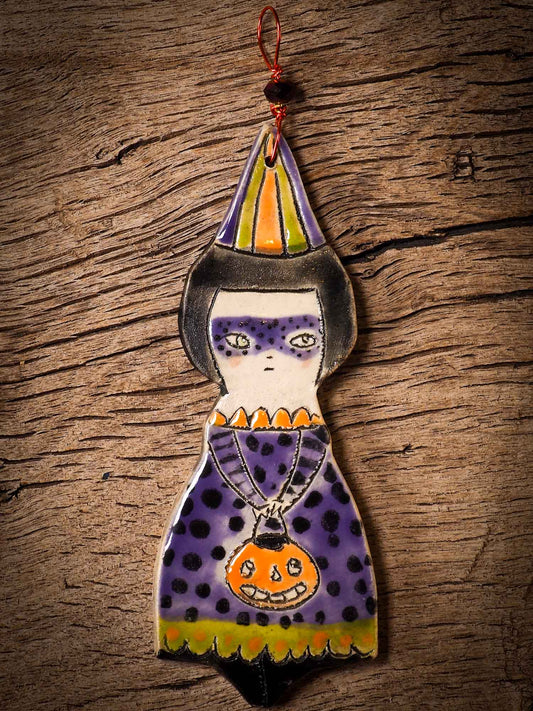 An original handmade Halloween ornament by Idania Salcido, Danita Art. Each ornament is hand carved with pumpkins, witches, cats, jack-o-lanterns and moons.  Made with fired glazed ceramics, this little witch, jack-o-lantern and cat is carved with delicate patterns that make each ornament a one of a kind work of art.
