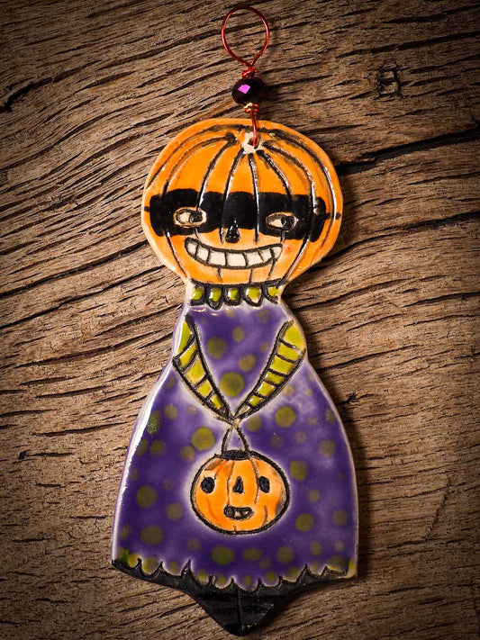 An original handmade Halloween ornament by Idania Salcido, Danita Art. Each ornament is hand carved with pumpkins, witches, cats, jack-o-lanterns and moons.  Made with fired glazed ceramics, this little witch, jack-o-lantern and cat is carved with delicate patterns that make each ornament a one of a kind work of art.