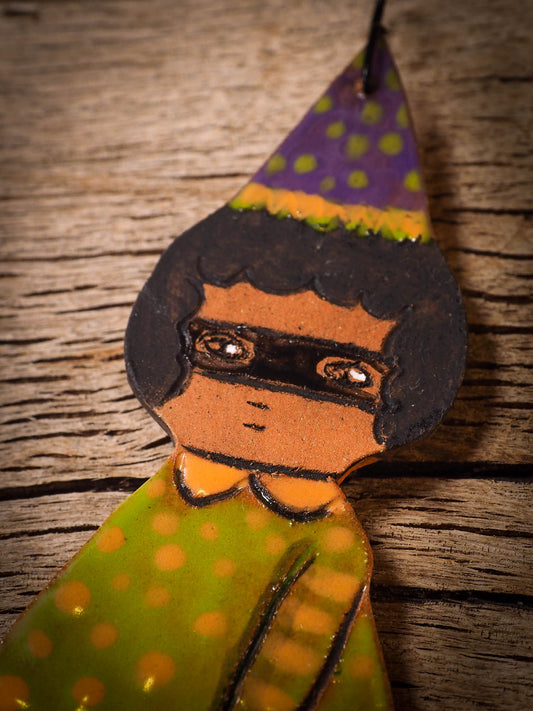 An original handmade Halloween ornament by Idania Salcido, Danita Art. Each ornament is hand carved with pumpkins, witches, cats, jack-o-lanterns and moons.  Made with fired glazed ceramics, this little witch, jack-o-lantern and cat is carved with delicate patterns that make each ornament a one of a kind work of art.