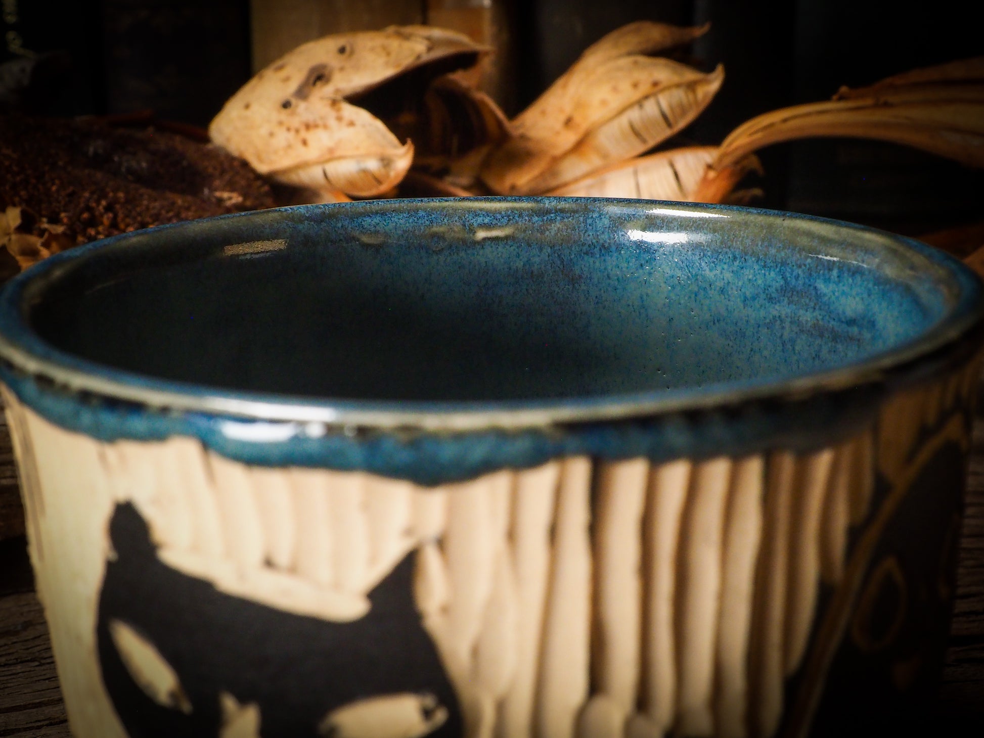 Fire glazed ceramic coffee mug by Idania Salcido, Danita Art. On Halloween, Danita creates ceramic containers for pumpkin spice coffee, warm tea or sweets to give on trick-or-treat night. With carved with Halloween ghosts, skeletons, witches, ghouls, black cats, jack-o-lanterns, item is food safe, hand wash only.