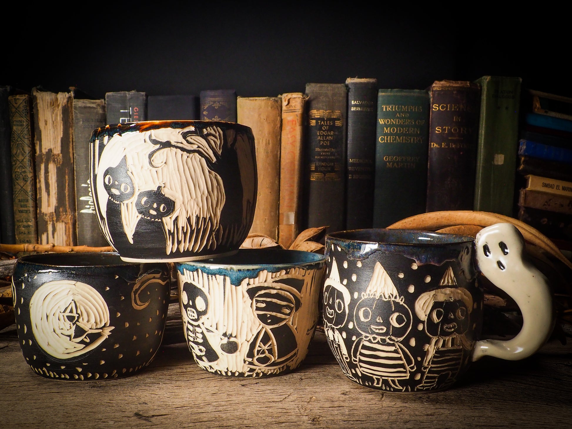 Fire glazed ceramic coffee mug by Idania Salcido, Danita Art. On Halloween, Danita creates ceramic containers for pumpkin spice coffee, warm tea or sweets to give on trick-or-treat night. With carved with Halloween ghosts, skeletons, witches, ghouls, black cats, jack-o-lanterns, item is food safe, hand wash only.