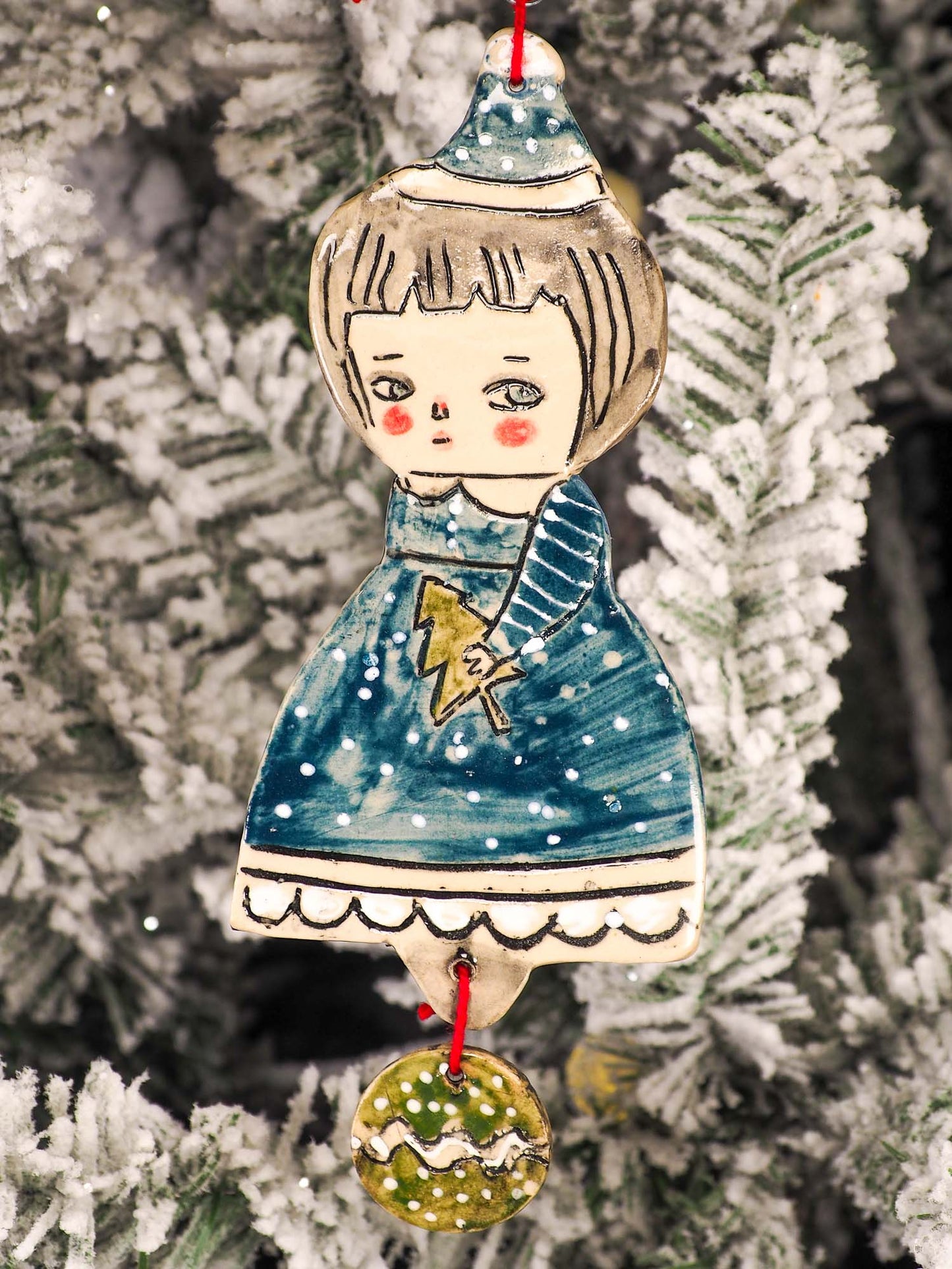 An original Christmas Holiday tree round glazed ceramic ornament handmade by Idania Salcido, the artist behind Danita Art. Glazed carved sgraffito stoneware, hand painted and decorated, it is illustrated by hand with snowmen, Christmas trees, Santa Claus, angels and snow balls and winter themes.